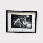 Photo en noir et blanc au format horizontal de deux messieurs âgés assis et discutant ensemble.