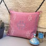 Kussensloop van cactuszijde, handgemaakt in Marokko. Roze met lichtblauwe en witte stiksels.