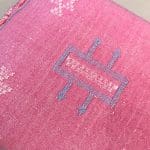 Kussensloop van cactuszijde, handgemaakt in Marokko. Roze met lichtblauwe en witte stiksels.