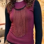 Collier de perles rouge bordeaux avec un collier tressé de la même couleur.