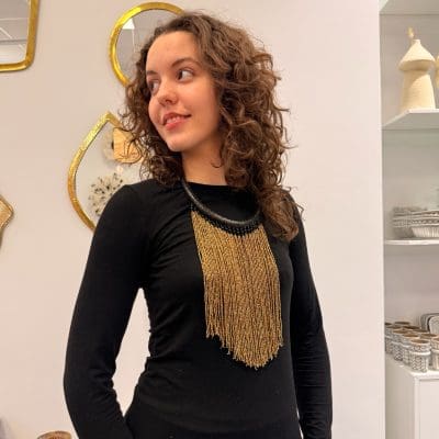 perlehalskæde i guld farver. sort halsring af flettet læder.