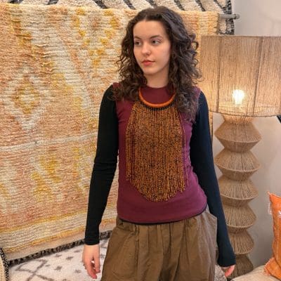 Halsketting met warme oranje en zwarte kralen en een oranje halsring van gevlochten leer.