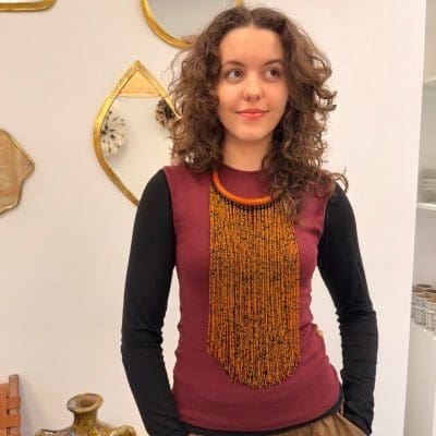 Halsketting met warme oranje en zwarte kralen en een oranje halsring van gevlochten leer.