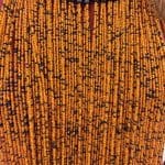 Halsband med varma orangea och svarta pärlor och orange halsring i flätat läder.