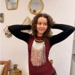 Pärlhalsband med halsring i ljusbrunt flätat läder och vita pärlor som dominerande färg. Orangea och gyllene pärlor blandas in och ger ett varmt och glödande uttryck, som påminner om saffran i snö.