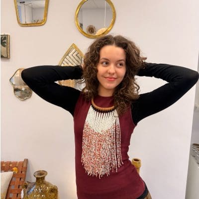 Perlehalskæde med halsring i lysebrunt flettet læder og de hvide perler som den dominerende farve. Orange og gyldne perler indblandet giver et varmt og glødende udtryk, der minder om safran i sne.