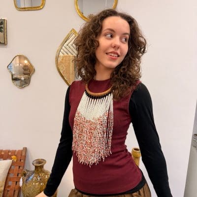 Perlehalskæde med halsring i lysebrunt flettet læder og de hvide perler som den dominerende farve. Orange og gyldne perler indblandet giver et varmt og glødende udtryk, der minder om safran i sne.