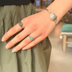 Eenvoudige zilveren ring met een zwarte steen in het midden.