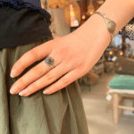 Zilveren ring met een prachtige steen, omringd door unieke, delicate zilveren gravures rond de zwarte steen in het midden.