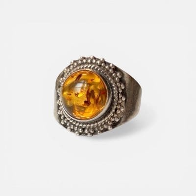 Honningring, rund glatt stein i midten i brunlige/gyldne nyanser omgitt av sølvdetaljer.