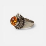 Honningring, rund glatt stein i midten i brunlige/gyldne nyanser omgitt av sølvdetaljer.