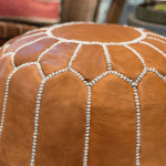Pouf en cuir de chèvre marron clair.