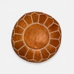 Pouf en cuir de chèvre marron clair.