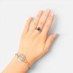 unik ring der viser to hænder der holder om et sort hjerte med en krone på.