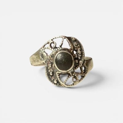 Zilveren ring met een prachtige steen, omringd door unieke, delicate zilveren gravures rond de zwarte steen in het midden.