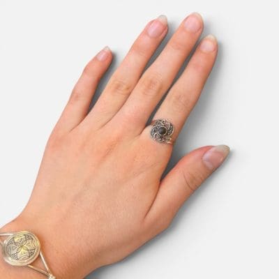 Zilveren ring met een prachtige steen, omringd door unieke, delicate zilveren gravures rond de zwarte steen in het midden.