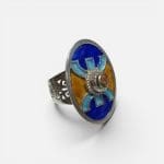 Bague en argent émaillé bleu et jaune, fabriquée à la main au Maroc. Pierre rougeâtre au centre.
