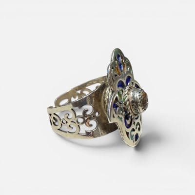 Beautiful Fatima ring with a reddish stone in the middle. Fine enamel details in yellow, green and blue. Silver carvings.