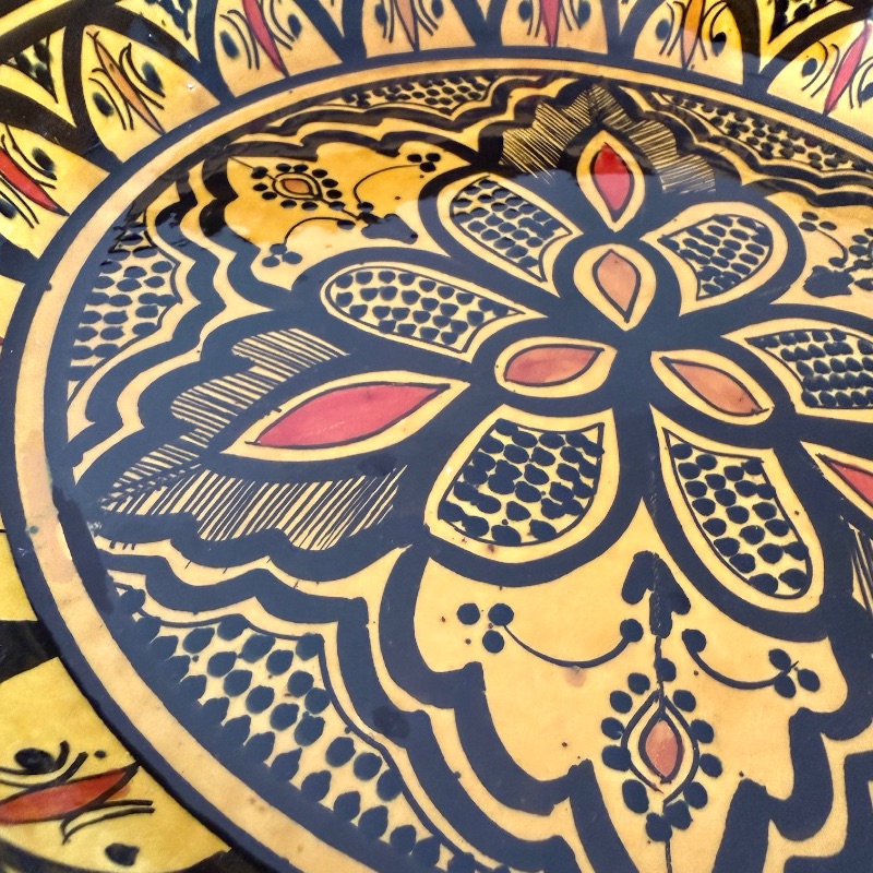 Couscous fad der måler 32 cm. i diameter i gul med et detaljeret mønster med sorte og orange detaljer. Håndlavet i Marokko.