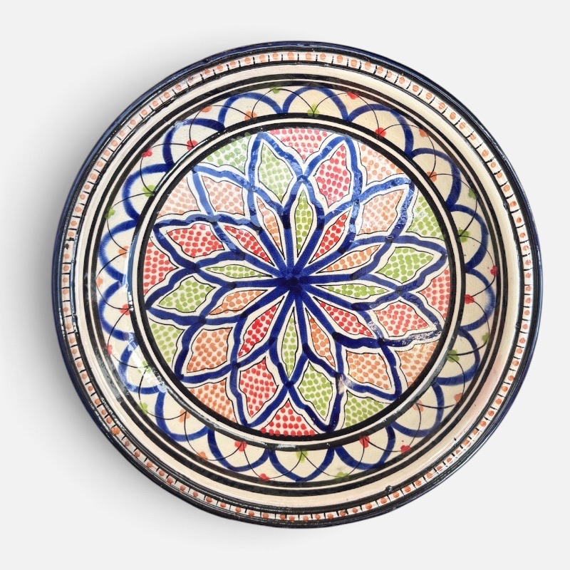27DC195E-4E0F-4A87-8066-CB4CD4D74C35 Couscousfat som måler 32 cm i diameter i marineblått med et detaljert karnevalsmønster av grønne og røde prikker. Håndlaget i Marokko.