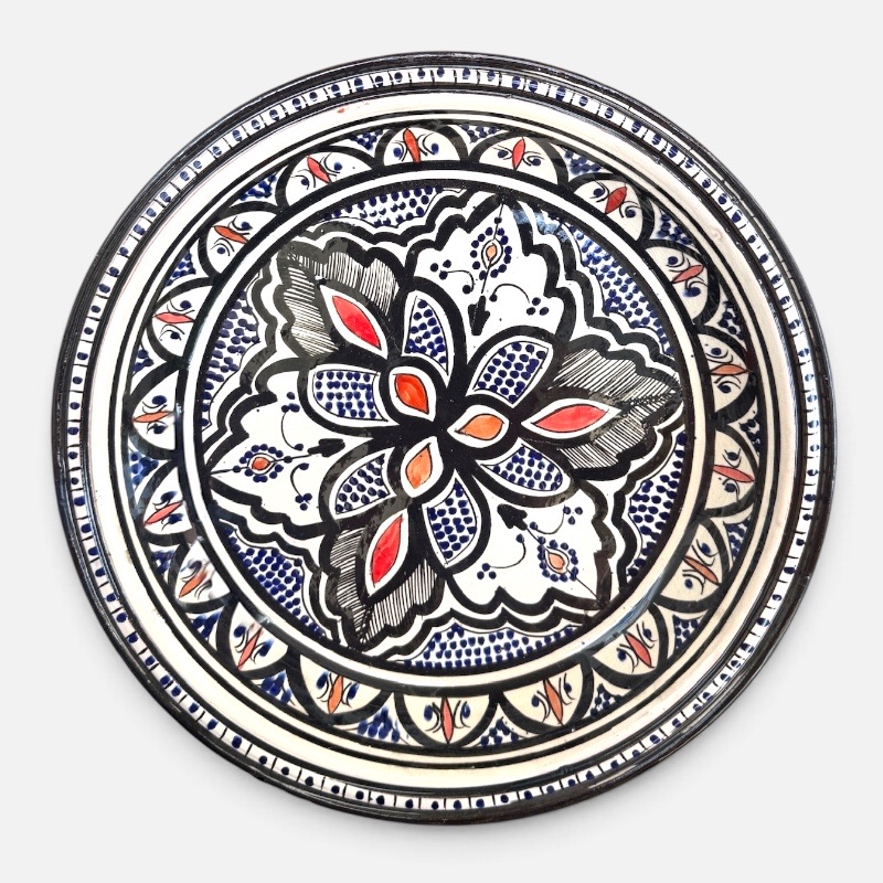 37D5ABD2-41F0-42BB-84CD-019156898B45 sort couscous fad med røde og orange detaljer med håndlavet mønster. Måler 32 cm i diameter og er håndlavet i Marokko.