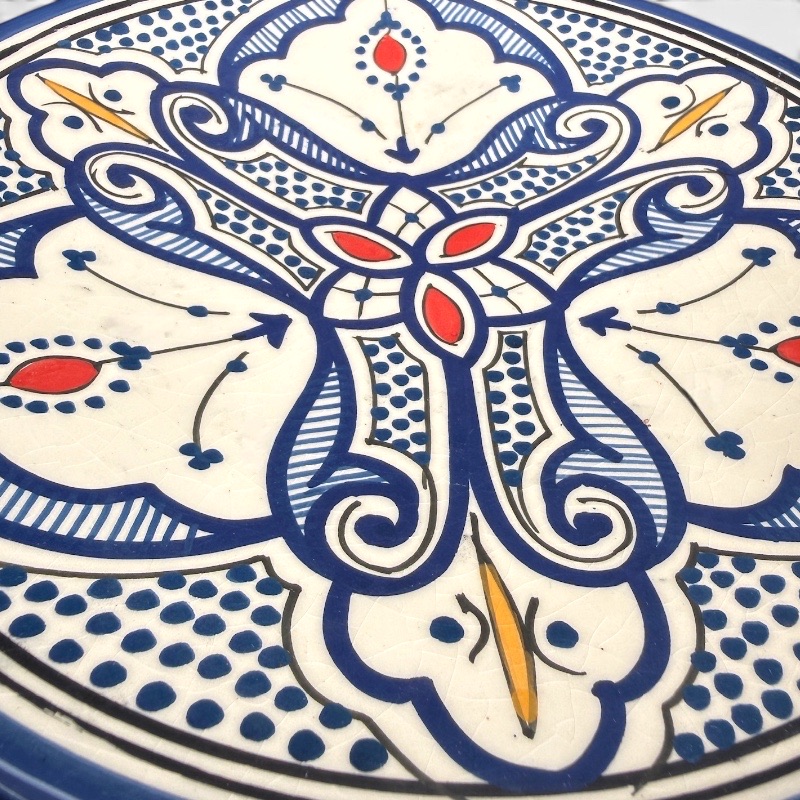 blå keramik tallerken med detaljer i gul og rød håndlavet i marokko. måler 26 cm.