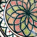 Couscous fad der måler 32 cm. i diameter i mørkegrøn med et detaljeret mønster i tivolistil med grønne og røde detaljer. Håndlavet i Marokko.