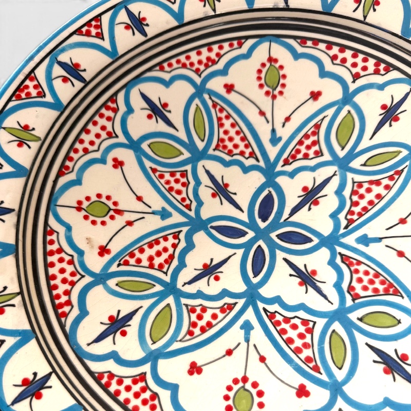 Marokkansk keramikkfat som måler 35 cm i diameter. Lyseblå med røde og grønne detaljer. Håndlaget i Marokko.
