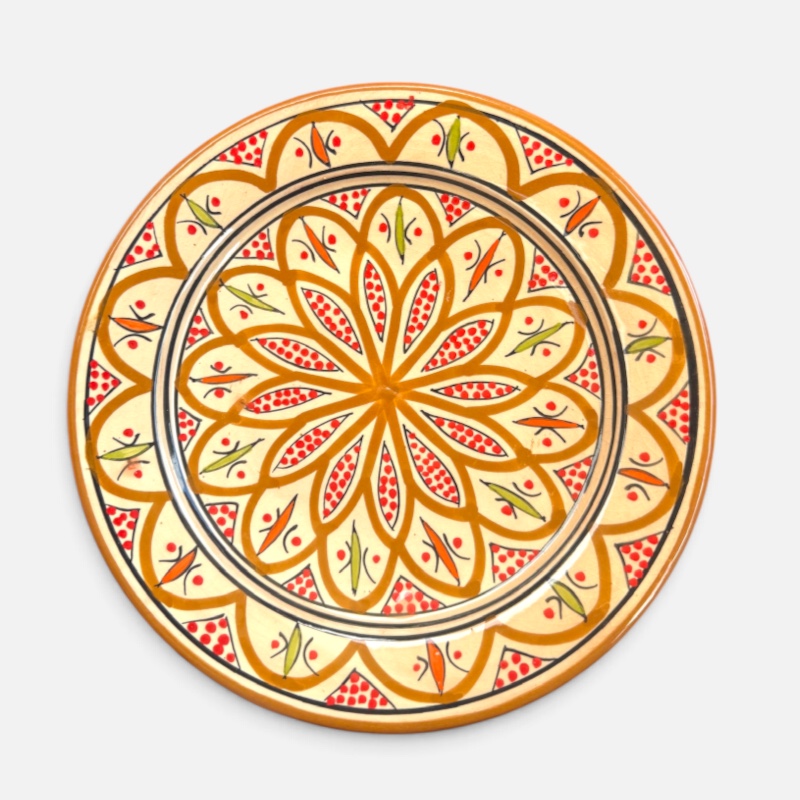 Assiette en céramique ocre ornée de détails rouges et verts, fabriquée à la main au Maroc. Dimensions : 26 cm.