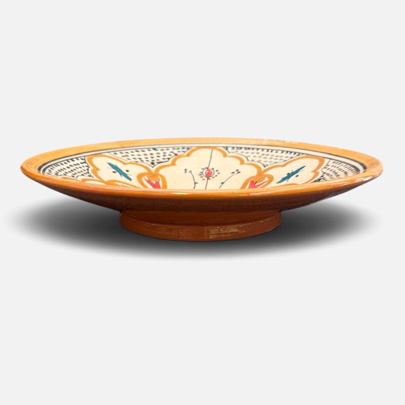 Assiette en céramique couleur ocre avec des détails couleur pétrole et orange, fabriquée à la main au Maroc, mesurant 26 cm.