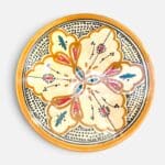 Assiette en céramique couleur ocre avec des détails couleur pétrole et orange, fabriquée à la main au Maroc, mesurant 26 cm.