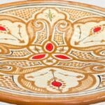 Assiette en céramique ocre avec détails rouges, fabriquée à la main au Maroc, mesurant 26 cm