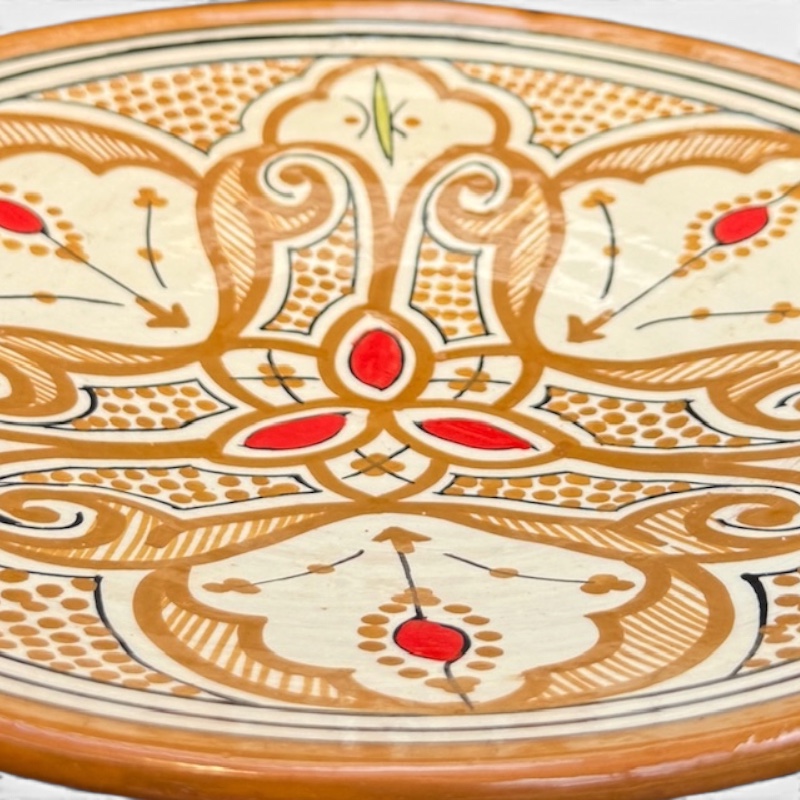 Assiette en céramique ocre avec détails rouges, fabriquée à la main au Maroc, mesurant 26 cm