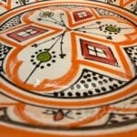 Magnifique plat à couscous en céramique de 28 centimètres de diamètre. Orange avec des détails verts et rouges, fabriqué artisanalement au Maroc.