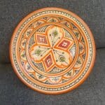 Magnifique plat à couscous en céramique de 28 centimètres de diamètre. Orange avec des détails verts et rouges, fabriqué artisanalement au Maroc.