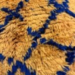 Coussin de sol Amaya en laine pêche à motif losanges bleus