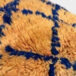 Coussin de sol Amaya en laine pêche à motif losanges bleus